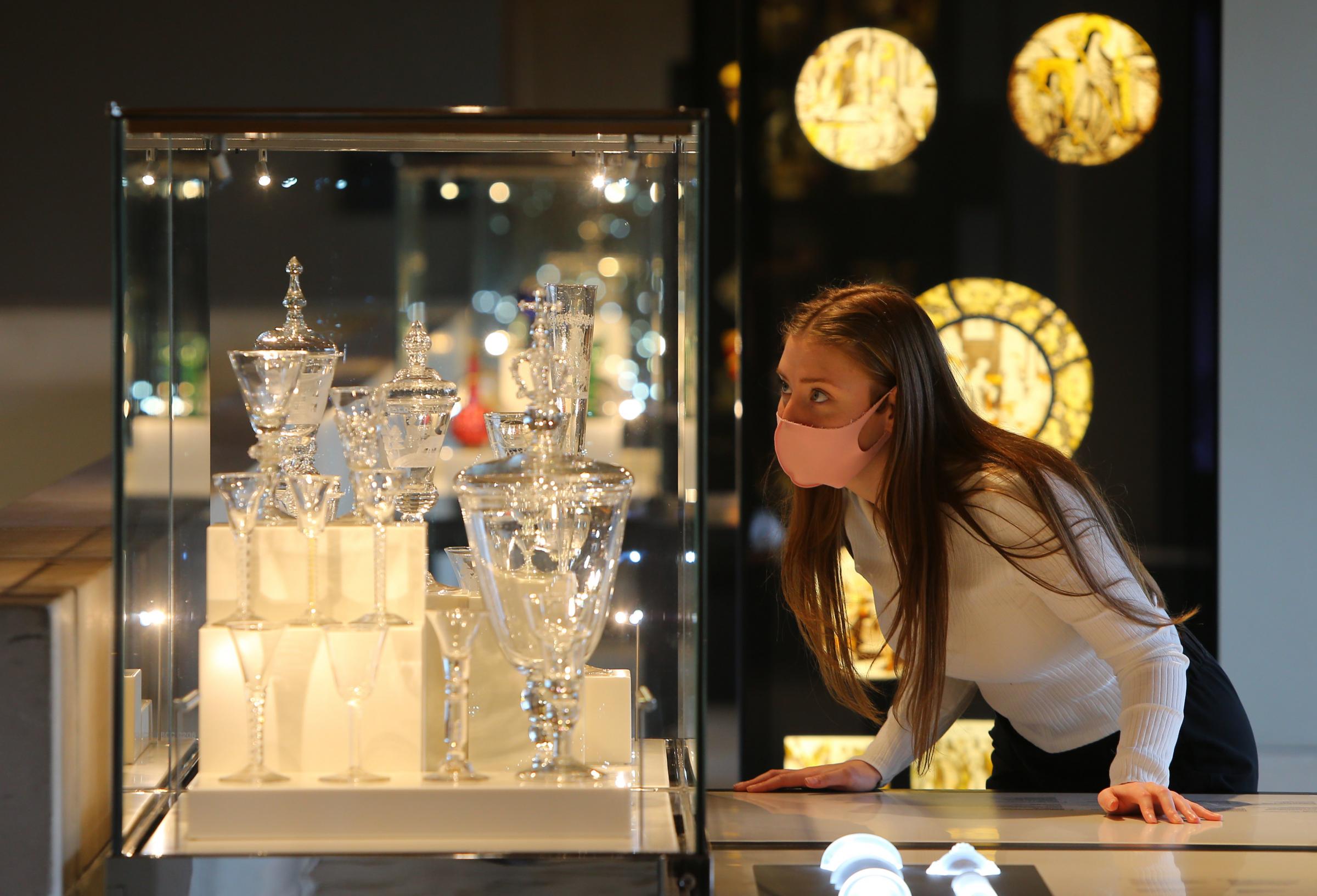 Burrell staff member Kirsty McAdam looking at a display of glass goblets. Photograph by Colin Mearns.