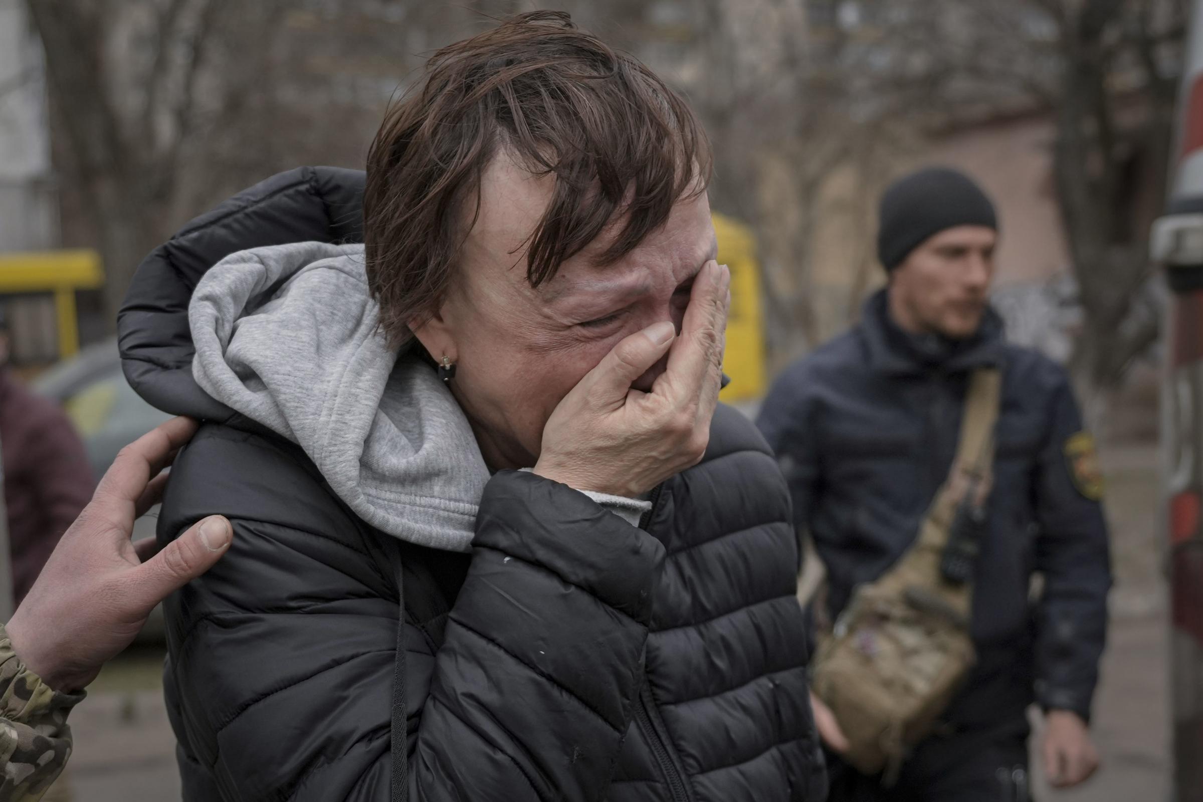 A woman evacuated from Irpin cries as she arrives on the outskirts of Kyiv, Ukraine.