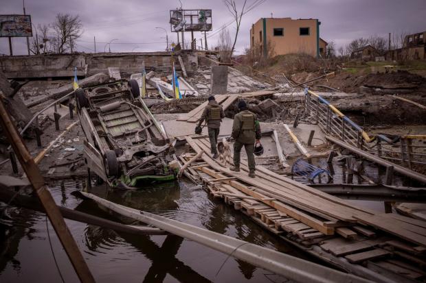 HeraldScotland: Ukrainian soldiers walk on a destroyed bridge in Irpin, on the outskirts of Kyiv (Emilio Morenatti/AP)