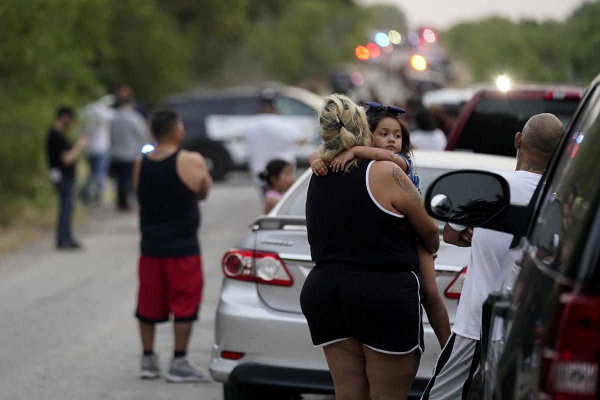 Onlookers stand near the scene where a semitrailer with multiple dead bodies was discovered, Monday, June 27, 2022, in San Antonio. (AP Photo/Eric Gay).