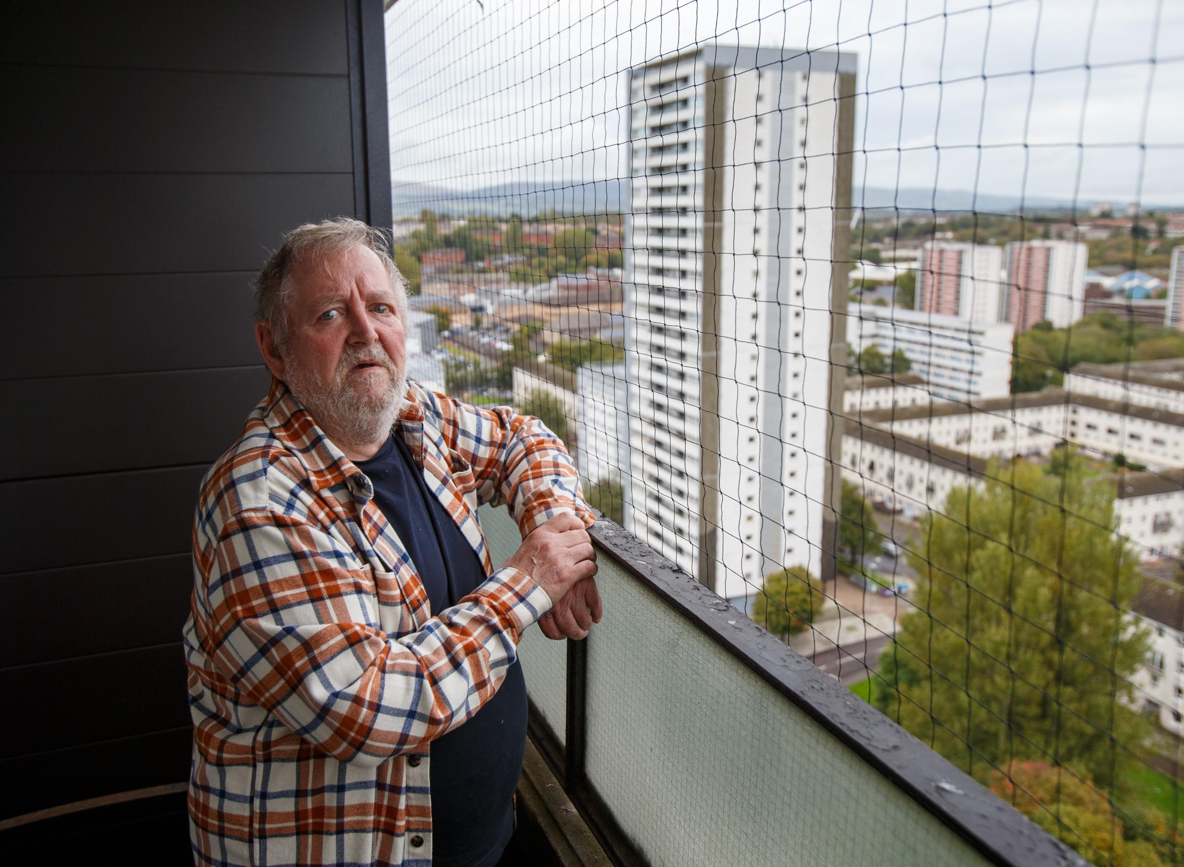 Gordon Goudie pictured on the balcony of his flat at 151 Wyndford Road, Maryhill. 151 is one of four tower blocks in the Wyndford that are earmarked for demolition. Photograph by Colin Mearns.