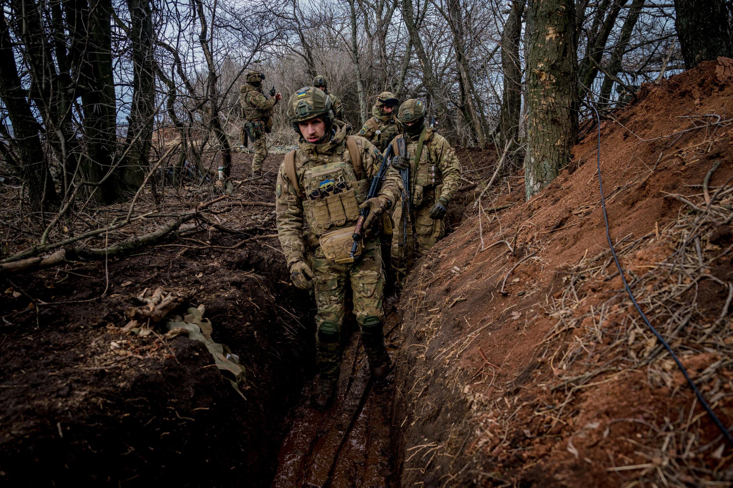 Ukrainian servicemen walk in a muddy trench near the frontline town of Bakhmut on March 2, 2023, amid the Russian invasion of Ukraine. (Photo by Dimitar DILKOFF / AFP) (Photo by DIMITAR DILKOFF/AFP via Getty Images).