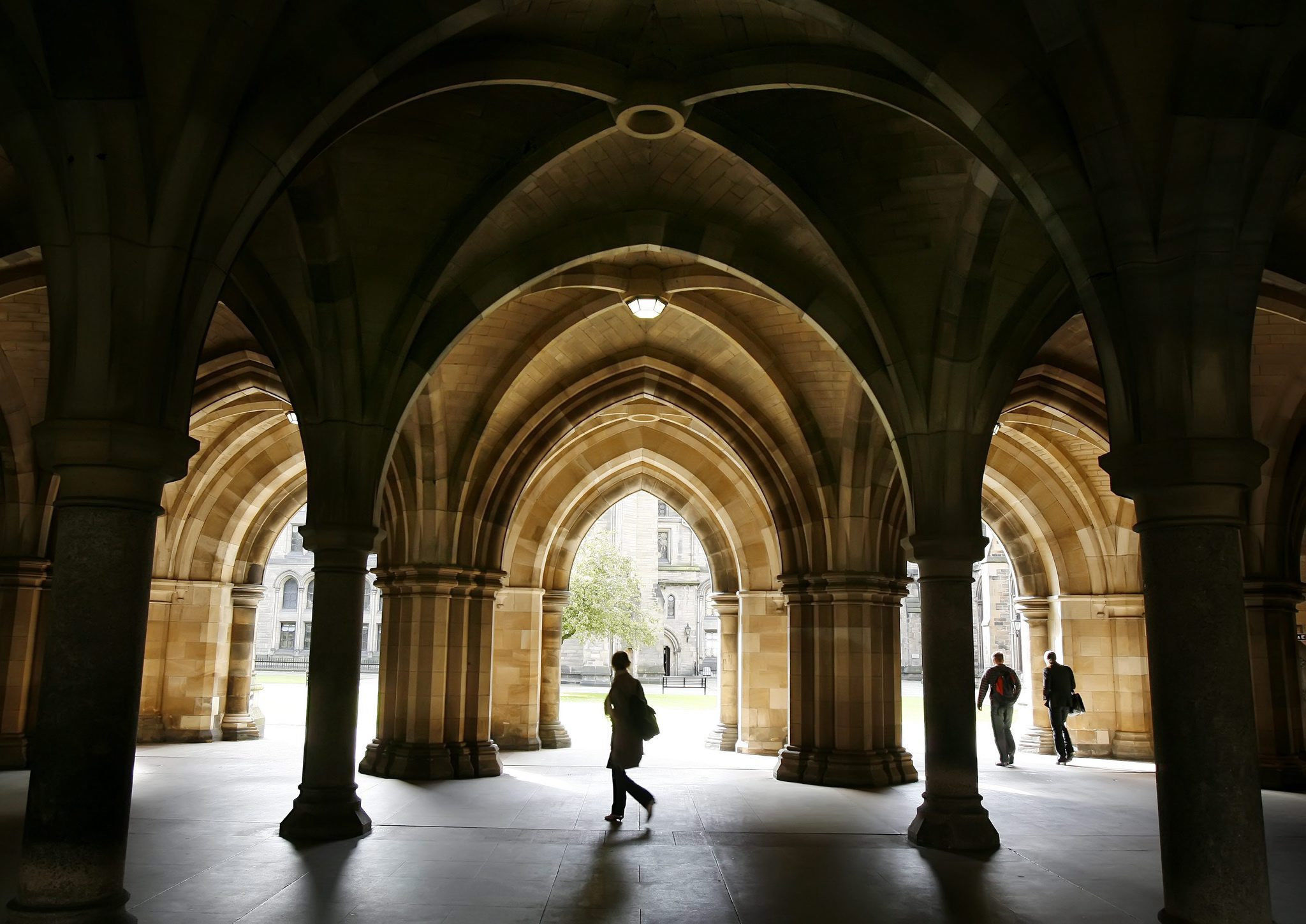 People walking among the cloisters beneath Bute Hall at the University of Glasgow..