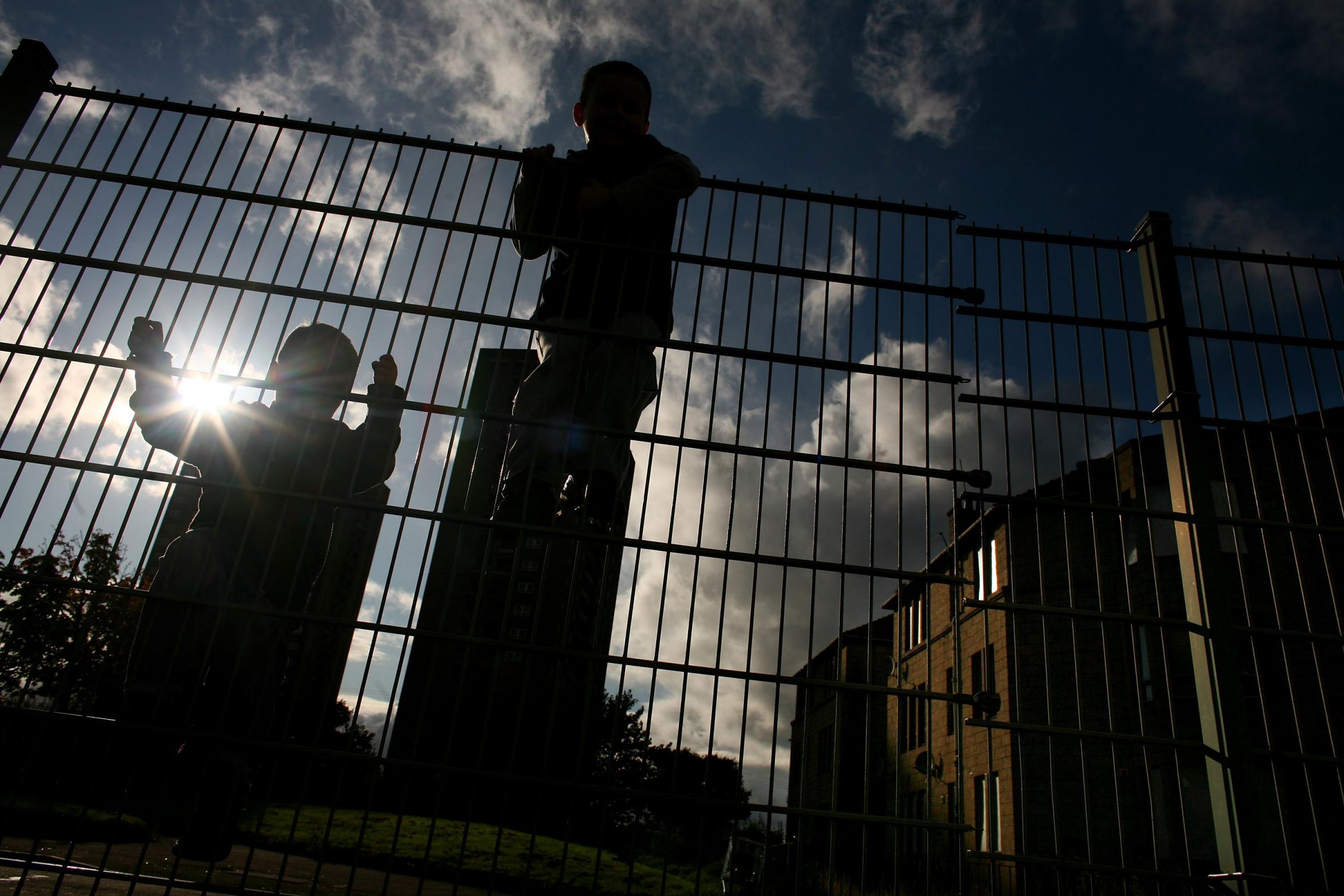 GLASGOW, UNITED KINGDOM - SEPTEMBER 30: (Editor’s note – since these images were taken the street pictured has been demolished) Two young boys climb on a fence in a street in the Govan neighborhood on September 30, 2008 in Glasgow, Scotland.