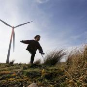 A child playing at a windfarm in Scotland