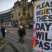 GLASGOW, SCOTLAND - APRIL 09: Members of the public walk past new posters placed around the city center on April 9, 2020 in Glasgow, Scotland. There have been around 60,000 reported cases of coronavirus (COVID-19) in the United Kingdom and 7,000 deaths.