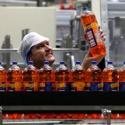 Mark Jephcott views bottles of Irn Bru in the production hall at AG Barr's Irn Bru factory in Cumbernauld as the secret recipe of Scotland's.