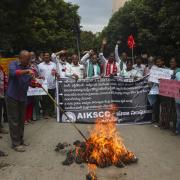 Indian farmers protesting against Sunday's killing of four farmers in Uttar Pradesh state after being run over by a car owned by India's junior Home Minister Ajay Mishra burn an effigy of the federal government in Hyderabad, India, Monday, Oct.