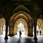 People walking among the cloisters beneath Bute Hall at the University of Glasgow.