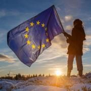 A young girl holds the flag of the European Union as she looks towards Whitelee Wind Farm outside Glasgow. Photo Colin Mearns.