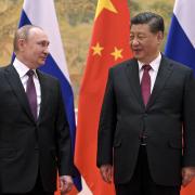 Chinese President Xi Jinping, right, and Russian President Vladimir Putin talk to each other during their meeting in Beijing, China, Friday, Feb. 4, 2022. Putin on Friday arrived in Beijing for the opening of the Winter Olympic Games and talks with his