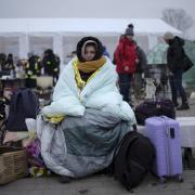 A woman covers herself with a blanket to keep warm after fleeing from the Ukraine and arriving at the border crossing in Medyka, Poland, today. Photo Markus Schreiber/AP