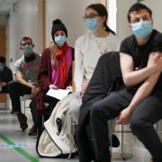 People wearing masks waiting to get their vaccine. Credit: PA