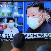People watch a TV screen showing a news program reporting with an image of North Korean leader Kim Jong-un, at a train station in Seoul, South Korea, Monday, May 16, 2022. Kim blasted officials over slow medicine deliveries and ordered his military to