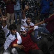 Students and activists shout slogans as Indian paramilitary personnel try to detain them following a protest demonstration against a new short-term government recruitment scheme for the military, in New Delhi, India, Friday, June 17, 2022. Hundreds of