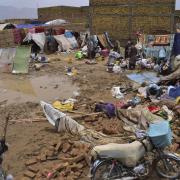 People salvage usable items from their house that was damaged by heavy rain, on the outskirts of Quetta, Pakistan, Tuesday, July 5, 2022. At least six people, including women and children, were killed when the roofs of their homes collapsed in heavy