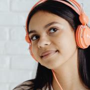 A girl wearing headphones. Credit: Canva