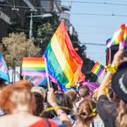 People holding and raising rainbow flags, symbol of the homosexual struggle, during a gay demonstration. The rainbow flag, commonly known as the gay pride flag or LGBT pride flag, is a symbol of lesbian, gay, bisexual and transgender (LGBT) pride and