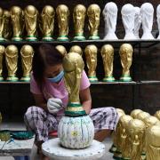 A Qatari woman makes replica World Cup trophies