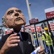 A protestor wears a Sepp Blatter mask