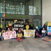 Protesters pose outside Scottish Power HQ in Glasgow as they call for action against fuel poverty