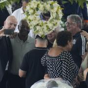 FIFA President Gianni Infantino, left, takes a selfie with Lima, a former Santos soccer player, and others, during the wake of the late Brazilian soccer great Pelé, who lies in state, at Vila Belmiro stadium in Santos, Brazil