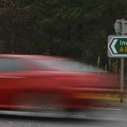 A car passes a sign on the A9 near Dalnamein, Perthshire.