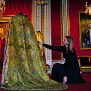 Caroline de Guitaut, deputy surveyor of the King's Works of Art for the Royal Collection Trust, adjusts the Imperial Mantle, which forms part of the Coronation Vestments, in the Throne Room at Buckingham Palace. The vestments will be worn by King Charles