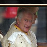 King Charles smiles as he makes his way to the Coronation service