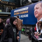 ISTANBUL, TURKEY - MAY 03: People walk past a picture of Turkish President Tayyip Erdogan in a busy shopping district on May 03, 2023 in Istanbul, Turkey. Persistently high inflation has led to a cost-of-living crisis in Turkey that has hurt President