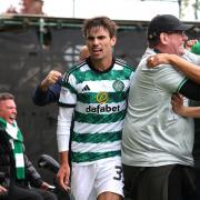Matt O'Riley celebrates with the Celtic fans after his late. late winner at Fir Park.