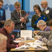 Officials count votes watched by party monitors