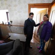 First Minister Humza Yousaf with Kim Clark as she shows him the mess inside her home following the floods during a visit to River Street in Brechin