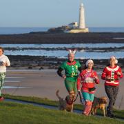 Runners dressed in festive outifits take part in the Christmas Eve park run at Whitley Bay in the North East of England