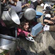 Palestinians line up for free food during the ongoing Israeli air and ground offensive on the Gaza strip