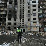 A policeman stands in front of a heavily damaged residential building, three days after a Russian missile attack in Kyiv, on January 5, 2024, amid the Russian invasion of Ukraine.