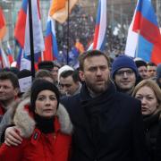 Russian opposition leader Alexei Navalny (C) embraces his spouse Yulia Navalnaya (L) attend a mass march marking the one-year anniversary of the killing of opposition leader Boris Nemtsov on February 27, 2016 in Moscow, Russia