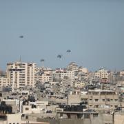 Humanitarian aid packages dropped from the air by Jordanian, US, Egyptian and French army planes are seen floating in the sky over Gaza City