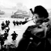 Piper Bill Millin in the foreground to the right, pipes Lord Lovat’s Commandos ashore on the Queen Red Beach sector of Sword Beach on D-Day