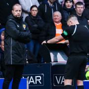 Referee John Beaton checks the pitchside monitor during the cinch Premiership game between Rangers and Celtic at Ibrox last Sunday as fourth official Willie Collum looks on