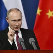 Russian President Vladimir Putin gestures as he talks with students of the Harbin Institute of Technology in Harbin, northeastern China