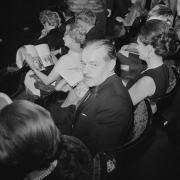 Scottish novelist Alistair MacLean (1922 - 1987) sitting among the crowd at a theatre, UK, 2nd April 1969
