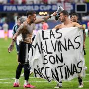 Argentina's Giovani Lo Celso holds a banner with the words 