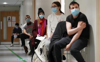 People wearing masks waiting to get their vaccine. Credit: PA