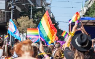 People holding and raising rainbow flags, symbol of the homosexual struggle, during a gay demonstration. The rainbow flag, commonly known as the gay pride flag or LGBT pride flag, is a symbol of lesbian, gay, bisexual and transgender (LGBT) pride and