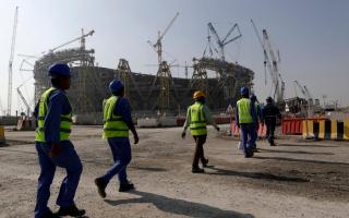 Construction workers walk to the Lusail Stadium in Qatar