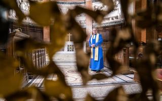 Parish minister Rev Peter Sutton stands alongside the nativity scene in St Cuthbert's Church, Edinburgh