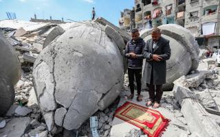 Palestinians pray during the second Friday prayer of the holy month of Ramadan on the ruins of Al-Farouq Mosque, which was destroyed by Israeli air strikes on March 22, 2024 in Rafah