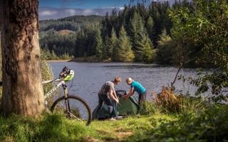 People Pitching Tent Next To Loch