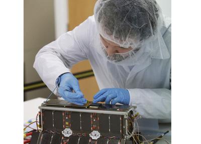 Kevin Worrall, Senior Engineer at Clyde Space, with the UKube-1 satellite, Scotland's first satellite, at Clyde Space in Glasgow.
